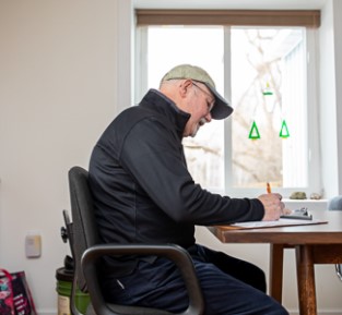charles kampmueller sits at a table and writes