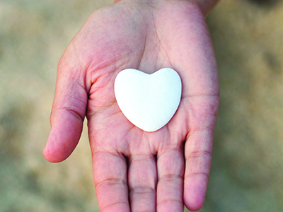 Heart-shaped stone in the palm of a hand