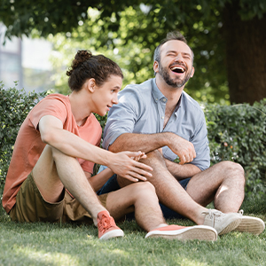 Men sitting on grass and laughing