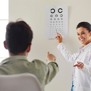 Child reading eye chart while healthcare provider points at letters