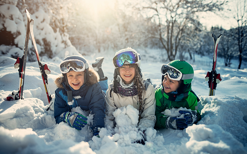 a group of young skiers smiling in the snow