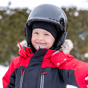 young child smiling with a full snowmobiling helmet