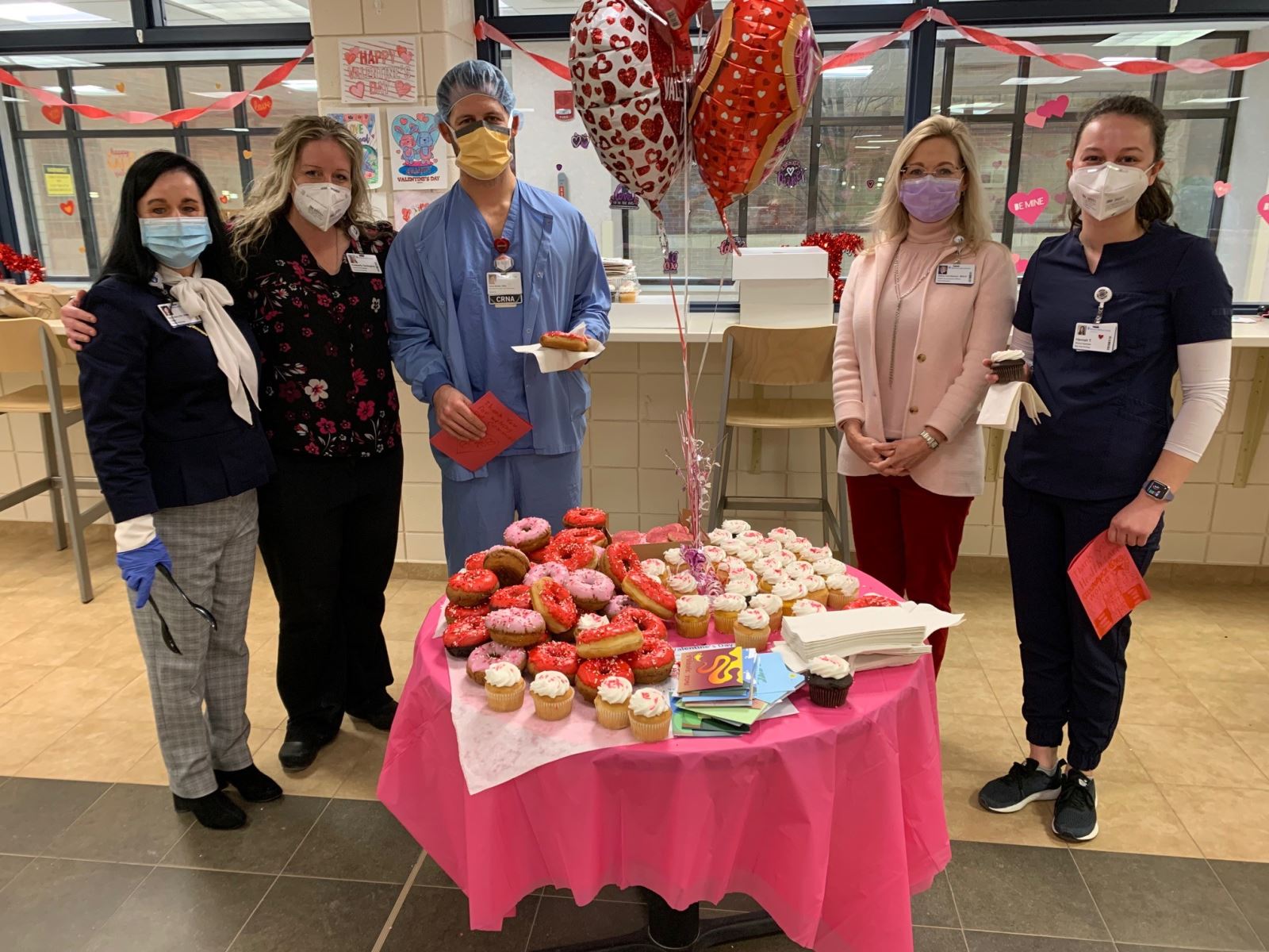 munson healthcare employees pose for a photo in the cafeteria on valentines day