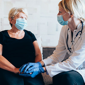 masked woman talking with a doctor