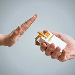 a person's hand refusing a box of cigarettes