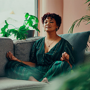 a woman meditating on the couch