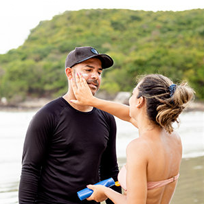 woman applying sunburn to man's face
