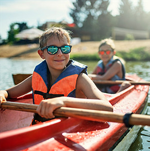 two kids kayaking while wearing sunglasses