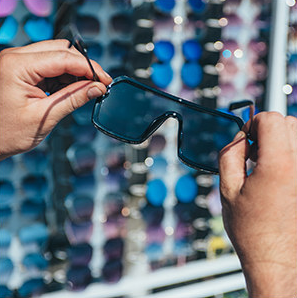 holding a pair of sunglasses while in a store